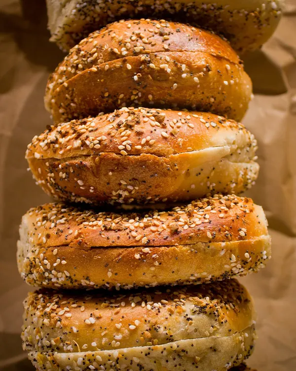 Stack of everything bagels with seeds and onion flakes