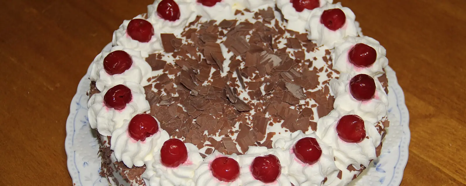 Black Forest cake with cream rosettes, cherries and chocolate shavings