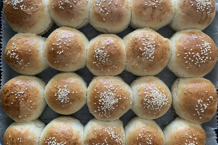 Tray of round egg buns topped with sesame seeds