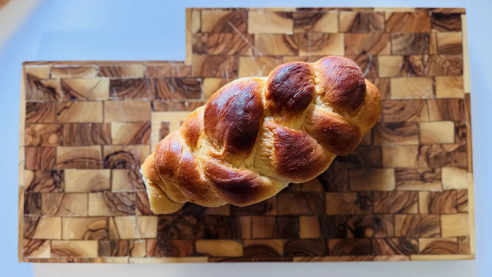 Braided challah loaf on a wooden board