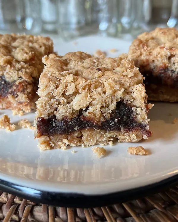 Date squares with an oat crumb top on a plate
