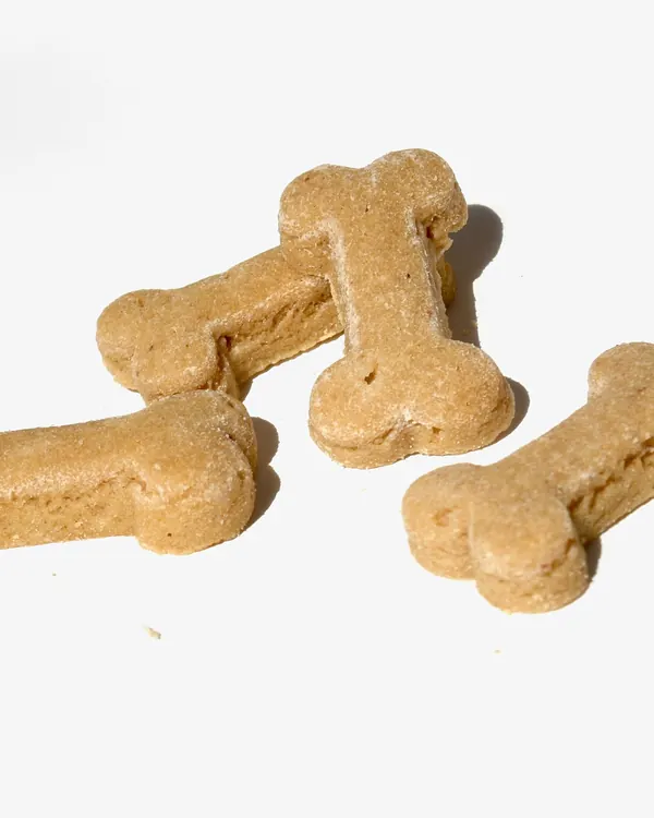 Three bone-shaped dog biscuits on white