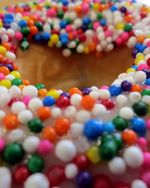 Doughnut covered with rainbow sprinkles, close up