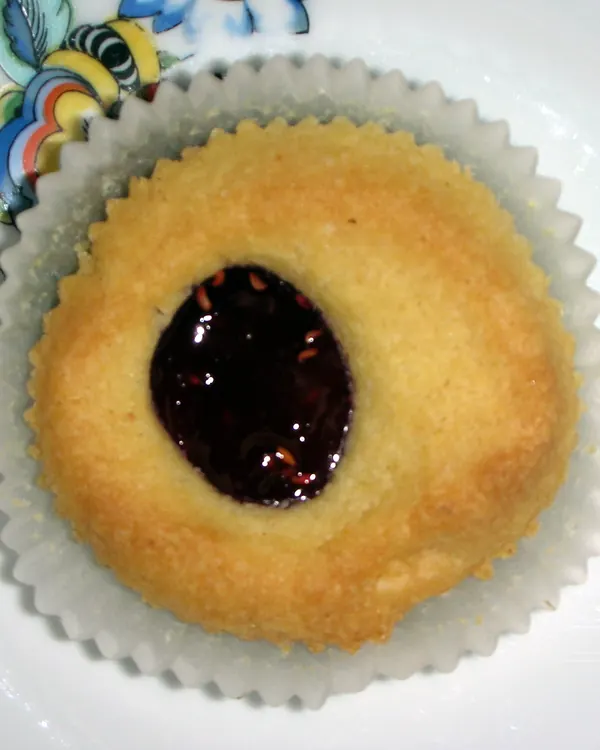 Round shortbread cookie with dark jam in the middle