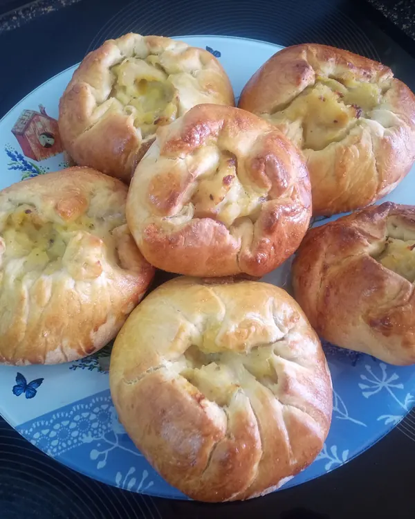 Round baked knishes on a blue plate