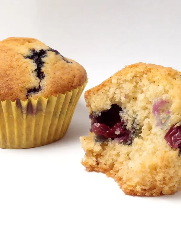 Two blueberry muffins, one torn open