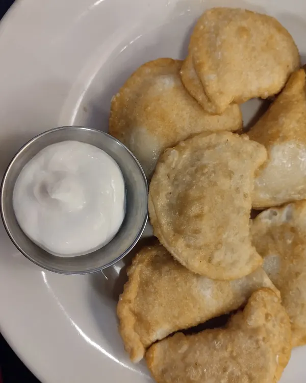 Pan-fried perogies with sour cream