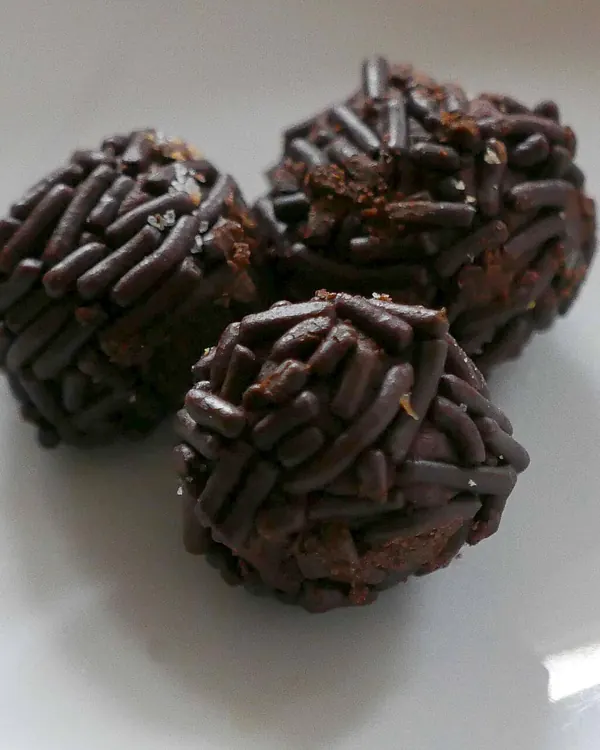Chocolate balls rolled in chocolate sprinkles on a white plate